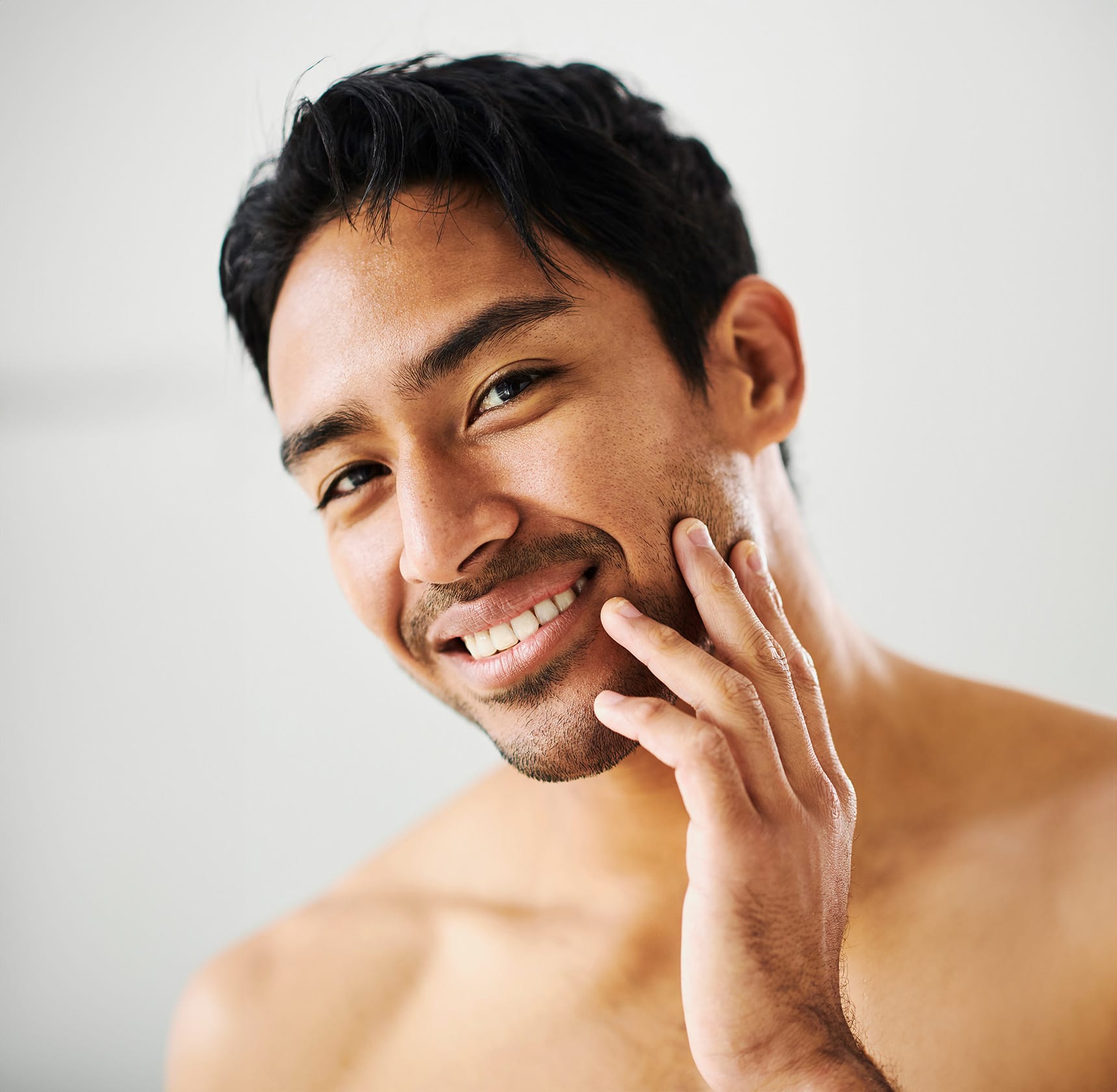 Man smiling touching face
