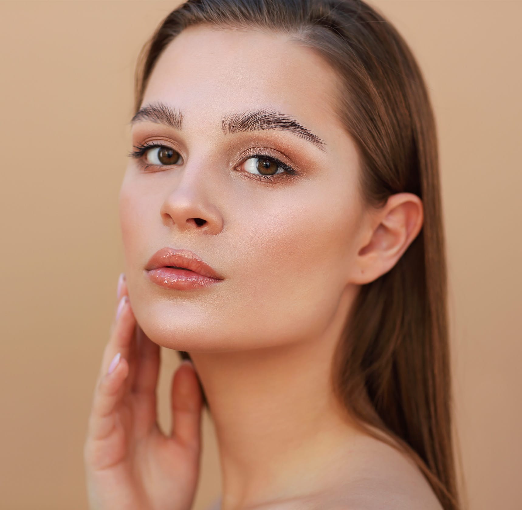 Woman looking at camera touching face