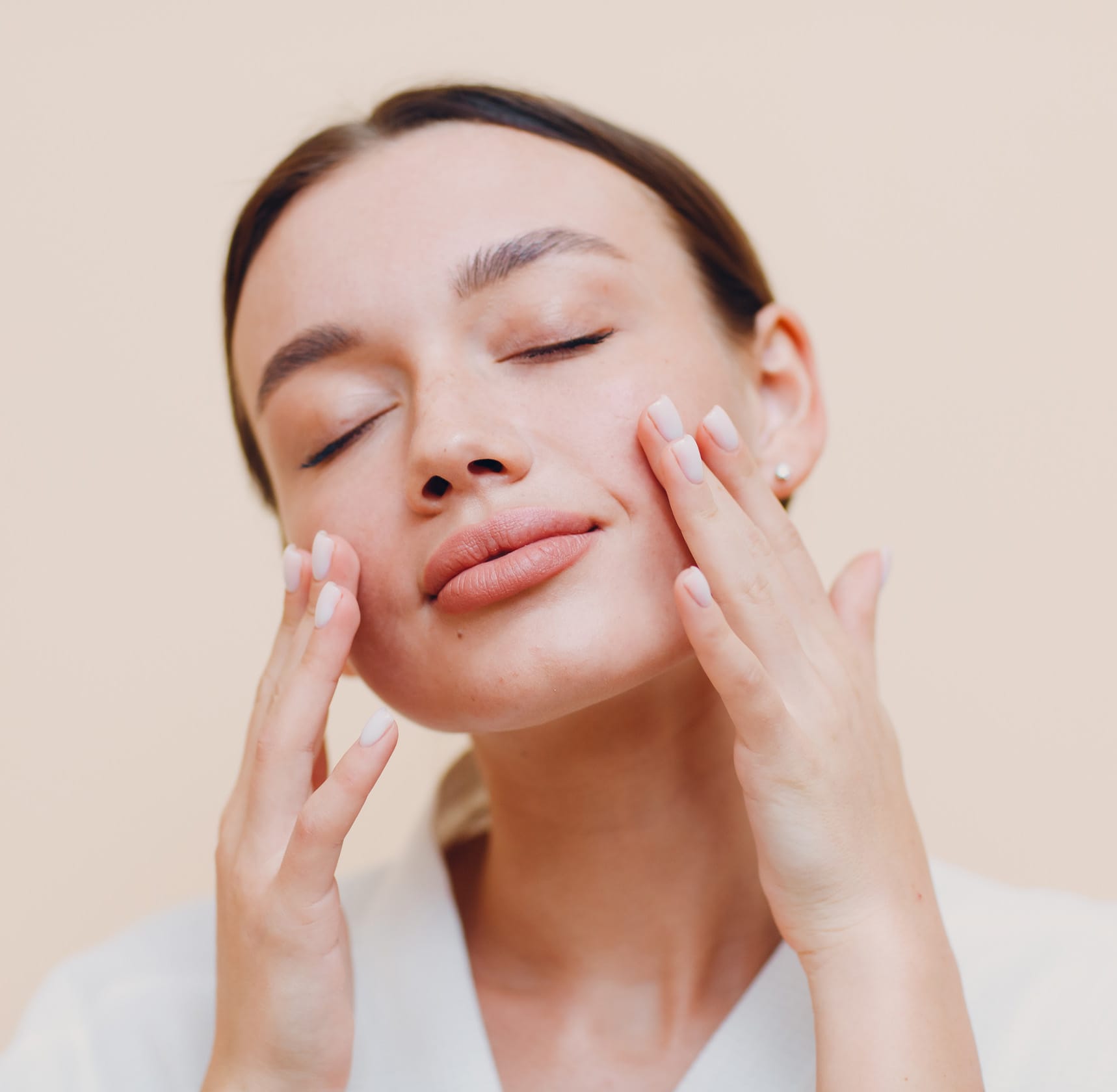 Woman touching face with eyes closed